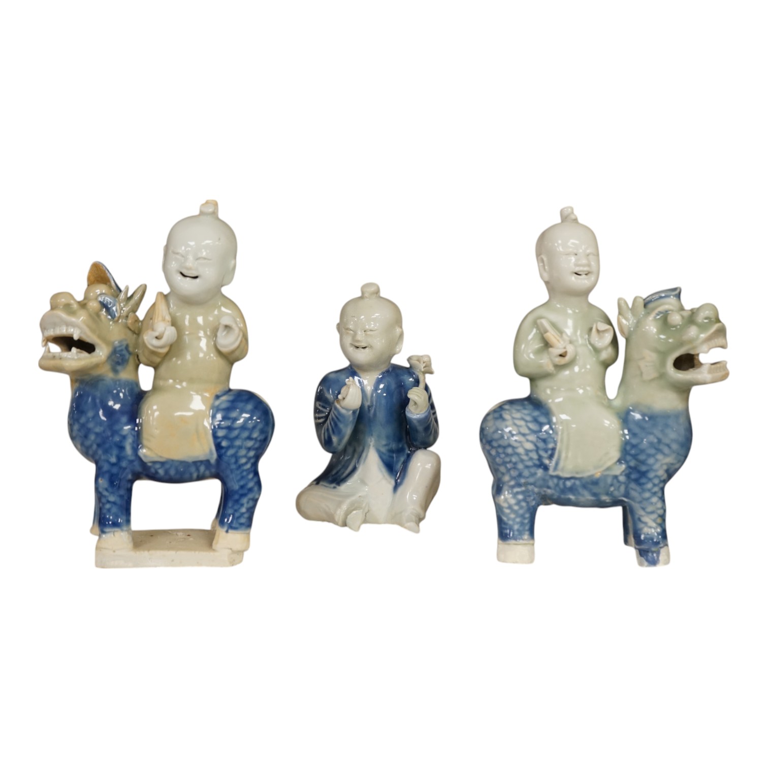 Three Chinese celadon and blue glazed porcelain boy figures, 18th century, largest 20cm high. Condition - fair, all restored